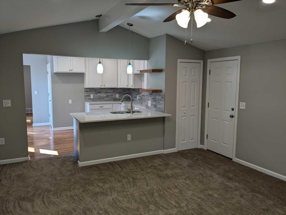 Swank Builders Inc remodeled interior with modern kitchen and adjoining living room in Flint MI