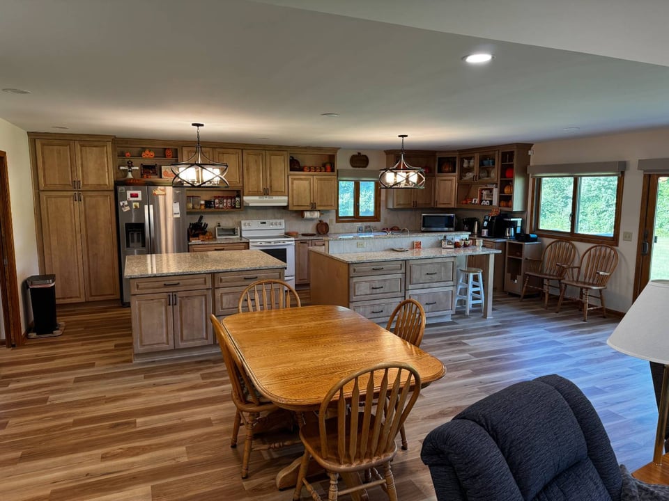 Large family kitchen remodel with granite countertops and dining area by Swank Builders Inc in Flint, MI.