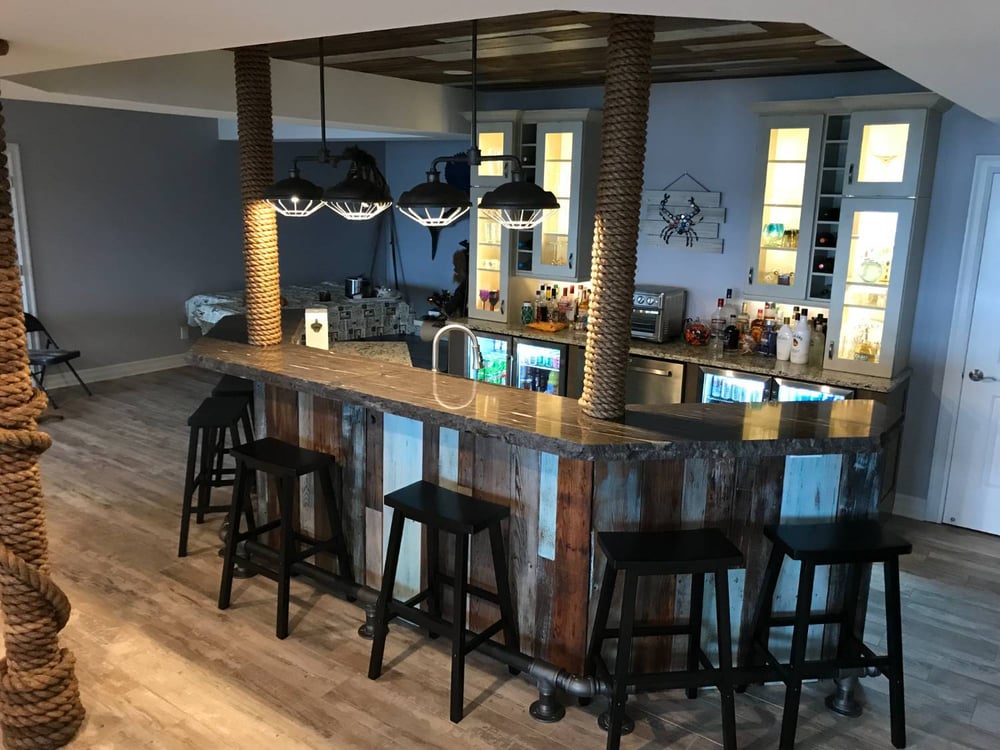 Luxury basement bar remodel with stone countertops and industrial lighting by Swank Builders Inc in Flint, MI