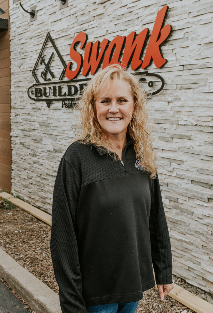 Debbi Halleck of Swank Builders Inc custom home builder team member portrait outside office in Genesee County MI