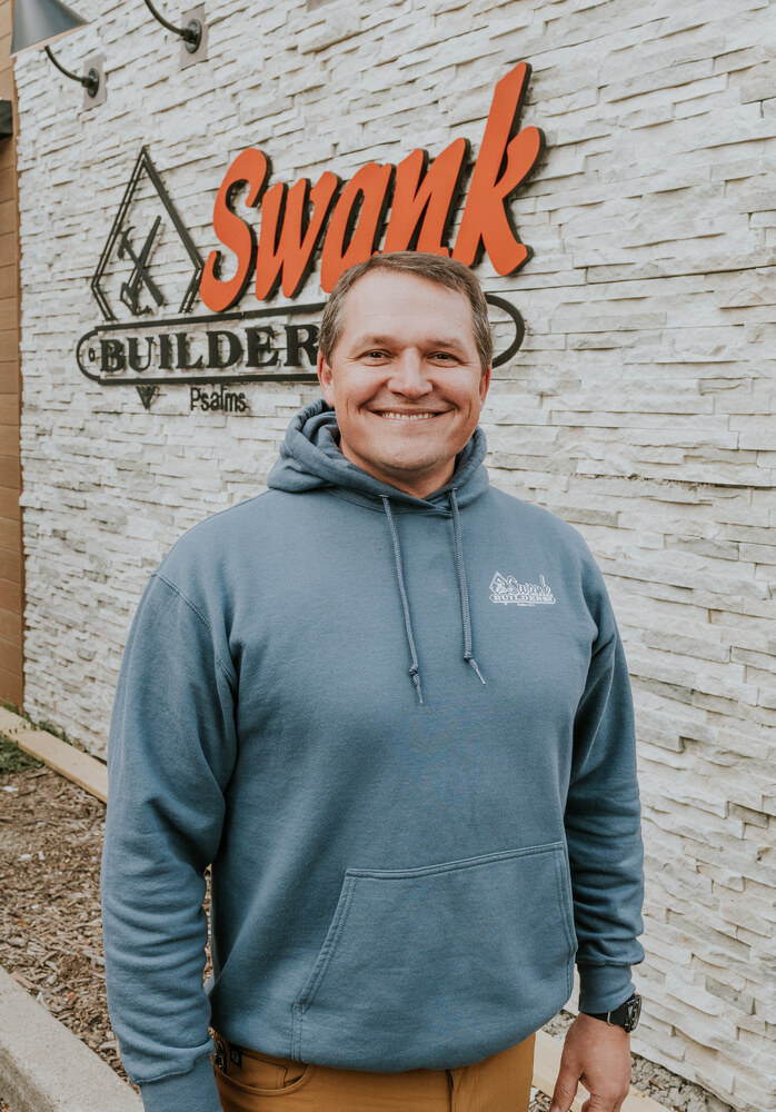 Seth Ferguson of Swank Builders Inc custom home builder team member portrait outside office in Genesee County MI