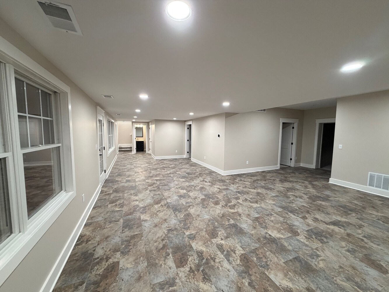 Swank Builders Inc custom finished basement with open concept layout and durable flooring in Michigan