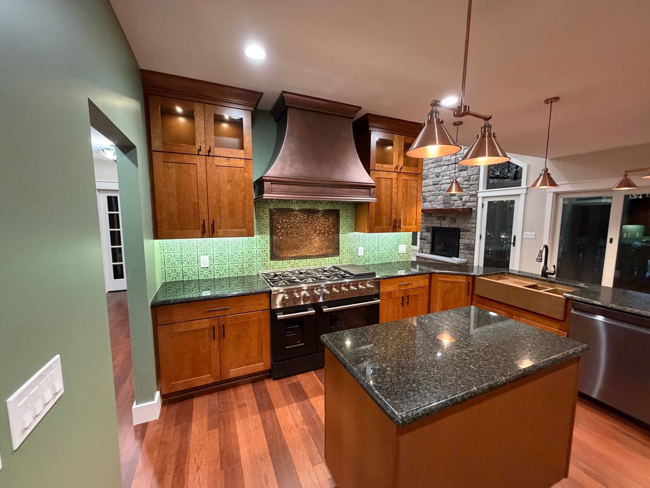 Swank Builders Inc custom kitchen with decorative range hood and tile backsplash in Michigan
