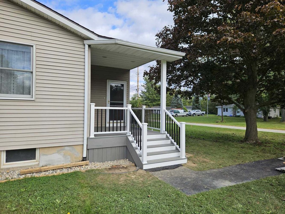 Swank Builders Inc backyard porch addition with steps and railing in Michigan