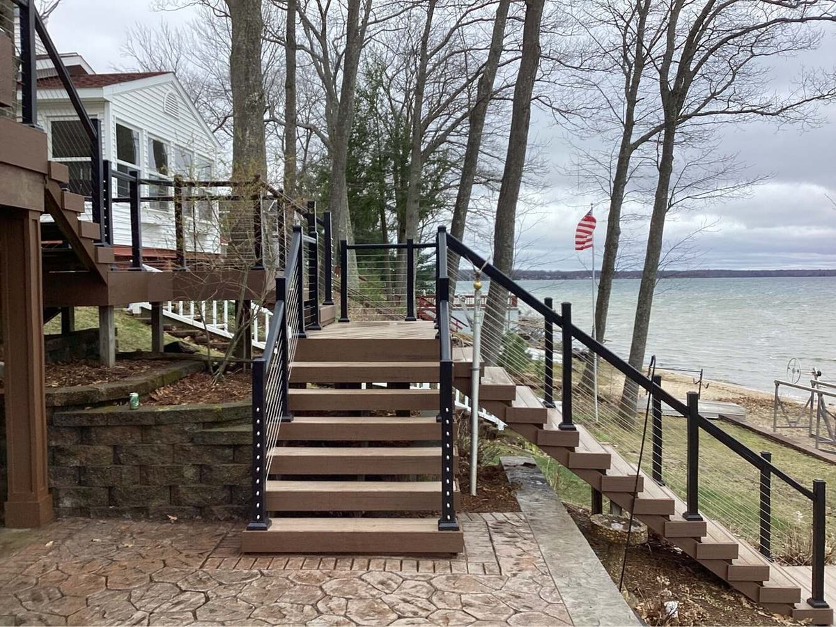 Swank Builders Inc waterfront deck with modern cable rail and multi-level stairs in Lake Fenton MI