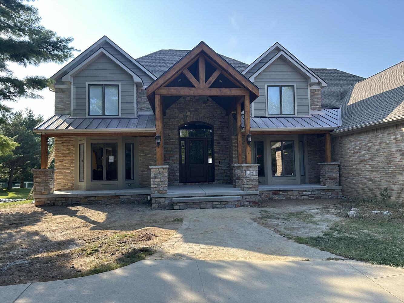 Finished front exterior remodel by Swank Builders Inc featuring a custom covered porch in Flint, MI.