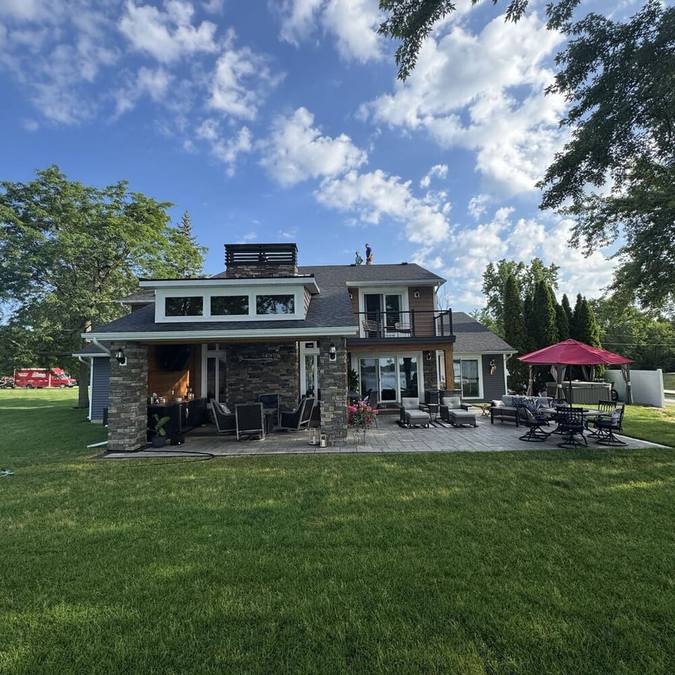 Swank Builders Inc whole home remodeling outdoor living renovation showing finished backyard patio and covered structure in Goodrich MI