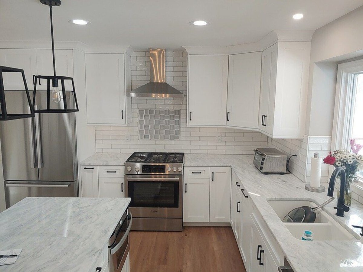 Modern kitchen renovation by Swank Builders Inc featuring a gas range and tile backsplash in Flint, MI.