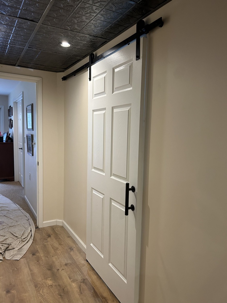 Swank Builders Inc bathroom remodel finished basement with sliding barn door and custom trim in Burton MI