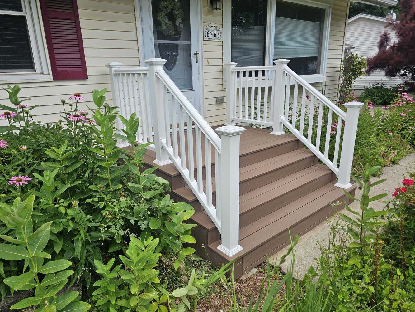 Swank Builders Inc front porch remodel with composite decking and white railing in Michigan