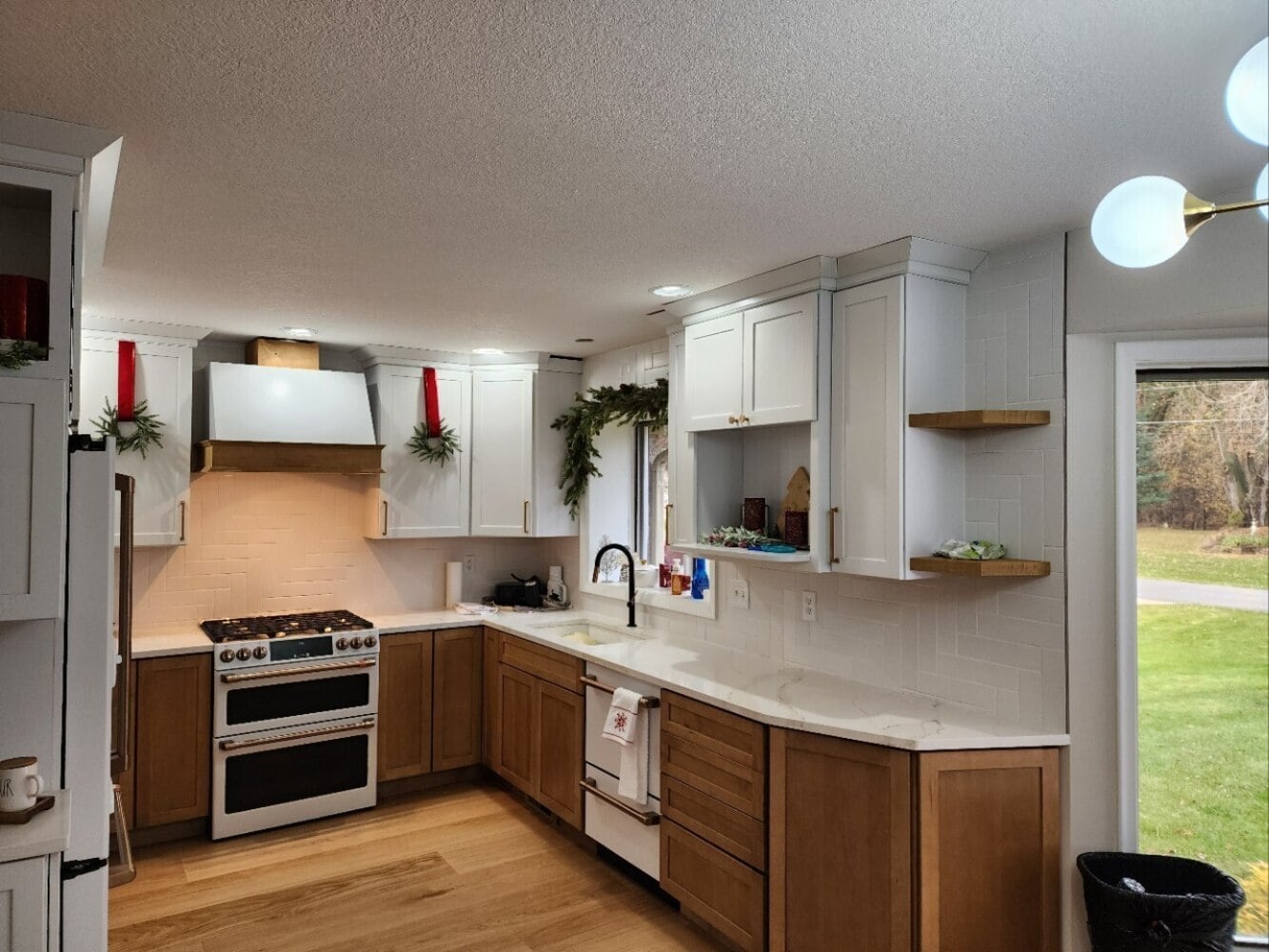 Swank Builders Inc bright kitchen renovation with quartz countertops and tile backsplash in Burton MI