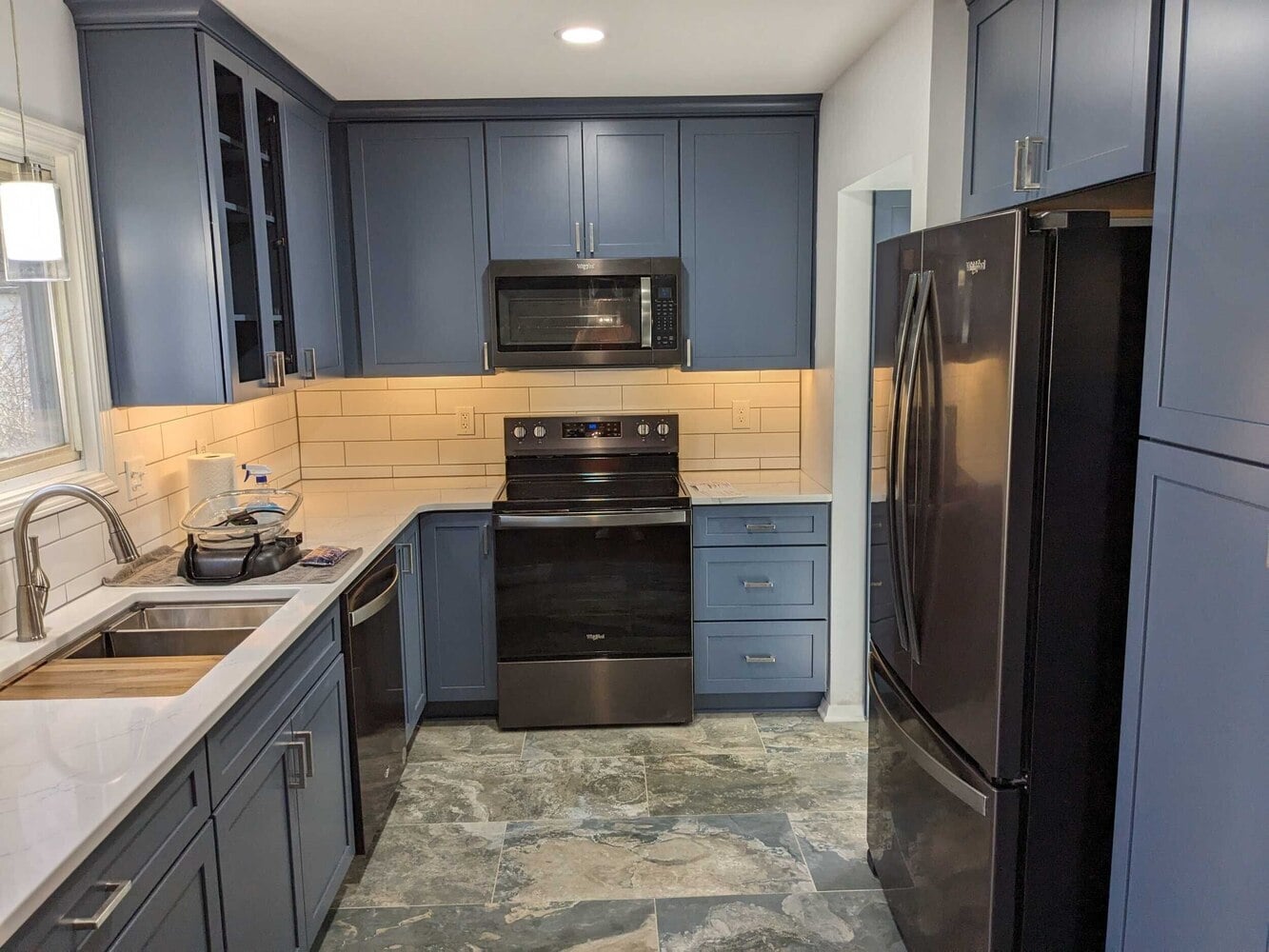 modern kitchen renovation with blue cabinets and durable flooring by Swank Builders Inc in Flint, MI
