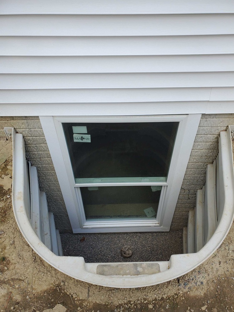 Swank Builders Inc installed a basement egress window with molded well system for safety and code compliance in Genesee County, MI.